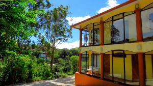 a yellow house with glass windows on a street at Hotel Santa Fe B&B in Monteverde Costa Rica