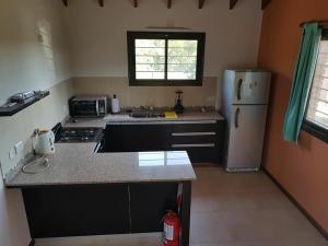 a kitchen with a stove and a refrigerator at Casa Crisolito in Merlo