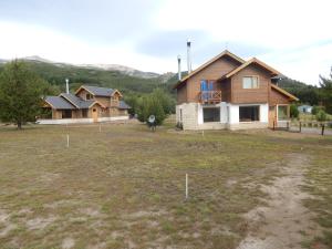 a house in the middle of a field with houses at Cabañas Wenuray in Lago Meliquina