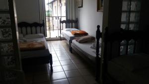 a bedroom with two beds and a window at Adry Hotel Inn Itajaí Navegantes in Itajaí