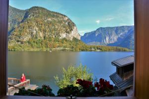 a person standing on a balcony looking at a lake at Haus Franziska in Hallstatt