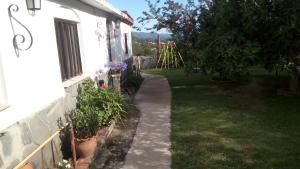 un jardin avec des plantes en pot à côté d'une maison dans l'établissement Apart Los Ciruelos, à Huerta Grande