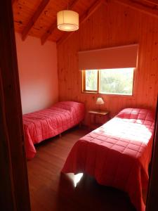 1 dormitorio con 2 camas y ventana en Cabañas Wenuray en Villa Meliquina