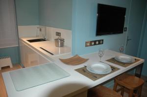 una cocina con una mesa con dos platos y vasos en Quimper-Appart en Quimper