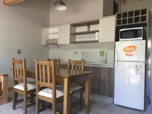 a kitchen with a table and a white refrigerator at Umain 33 in San Martín de los Andes