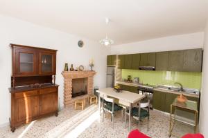 a kitchen with a table and a fireplace at Il Mandorlo in Ficulle