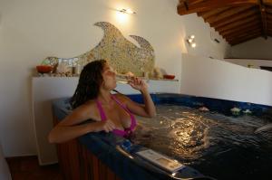 a woman sitting in a bath tub holding an umbrella at Santa Maria Resort in Orosei