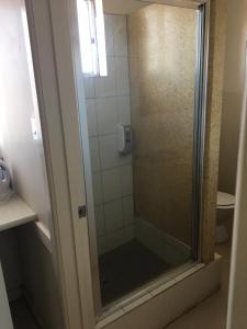 a shower with a glass door in a bathroom at Yarram Commecial Hotel Motel in Yarram