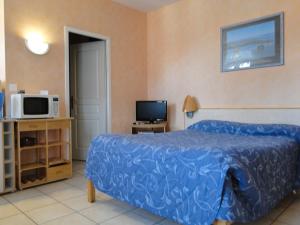 a bedroom with a bed and a microwave and a tv at Résidence L'Aquarium in Arcachon