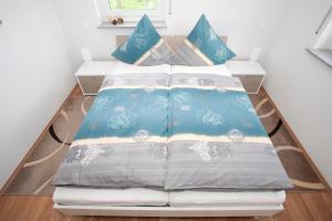 a bed with blue and white sheets and pillows at Haus am Apfelhain in Gangelt