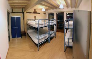 a room with three bunk beds in a room at El Albergue de la Catedral in Vitoria-Gasteiz