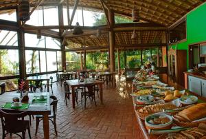 a restaurant with tables and chairs and food on display at Resort Refúgio do Estaleiro in Porto Belo