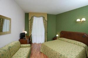 a hotel room with two beds and a window at Hotel La Torretta in Castel San Pietro Terme