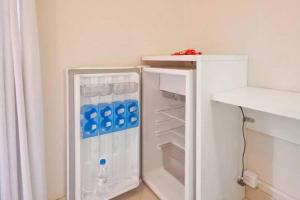 a white refrigerator with its door open in a kitchen at HomeStay 3 na Carlos Gomes não tem garagem in Porto Alegre
