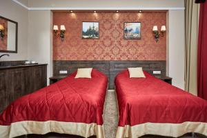 two beds in a room with red comforter at Gostinitsa Krasnaya in Blagoveshchensk