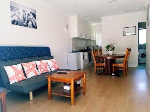een woonkamer met een bank en een tafel bij New Smart Home Nearby Plaza in Auckland