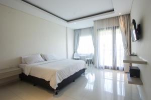 Un dormitorio blanco con una cama grande y ventanas en Soraya Apartment Seminyak, en Seminyak 24 fotos más