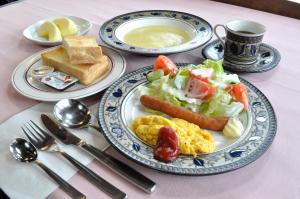 uma mesa com dois pratos de comida para o pequeno almoço em Pension Risuno Koya em Hakuba