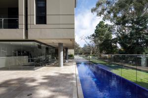 a house with a swimming pool next to a building at Knightsbridge Canberra in Canberra
