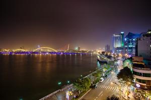 eine Skyline der Stadt in der Nacht mit einem Fluss und einer Brücke in der Unterkunft Catinal Hotel in Đà Nẵng