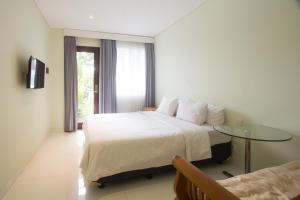 Un dormitorio con una cama y una mesa de cristal. en Soraya Apartment Seminyak, en Seminyak