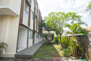 Un pasillo de un edificio con árboles y plantas. en Soraya Apartment Seminyak, en Seminyak