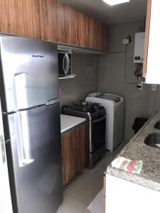 a kitchen with a stainless steel refrigerator and a stove at V G Fun Praia Do Futuro in Fortaleza