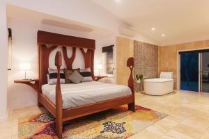a bedroom with a wooden bed and a bath tub at Deja Vu Estate in Pokolbin