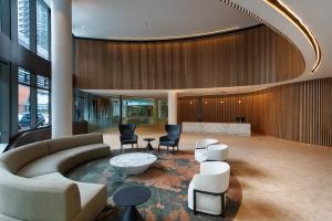 a lobby with a couch and chairs and a bed at Orange Stay Apartments in Melbourne +47 photos
