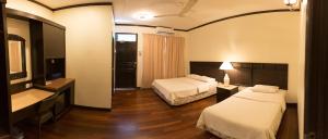 a hotel room with two beds and a desk at Tuna Bay Island Resort in Perhentian Islands