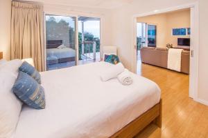 a bedroom with a large white bed and a balcony at Yaringa in Dunsborough