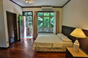 a bedroom with a bed and a large window at Tuna Bay Island Resort in Perhentian Islands