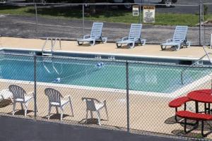 a fence with chairs and a swimming pool at America's Best Inn & Suites Eureka in Eureka