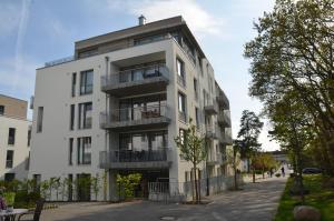 a white building with balconies on a street at DünenResort Binz - Apt. 3.8 in Binz