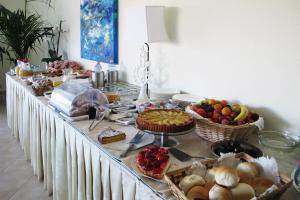 a long table with a buffet of food on it at Hotel Stella Marina in San Teodoro