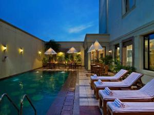 a swimming pool with lounge chairs and a building at Best Western Plus Jalandhar in Jalandhar