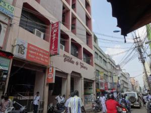 a busy city street with buildings and people on motorcycles at Hotel Pearls in Madurai