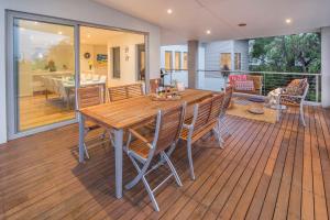 una mesa de madera y sillas en una terraza en Calm Waters en Dunsborough