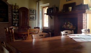 a dining room with a wooden table and chairs at Agriturismo Poggio alle Calle in Saturnia