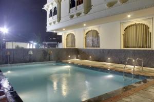 a swimming pool in the middle of a building at night at Hotel Riddhi Inn in Udaipur