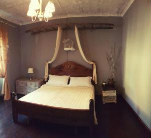 um quarto com uma cama grande e uma cabeceira em madeira em La mia casa di campagna em Rovieto