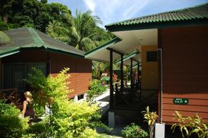 a woman standing in front of a house at Tuna Bay Island Resort in Perhentian Islands