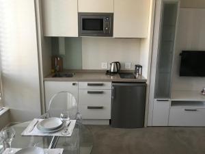 a small kitchen with a table and a microwave at Sandton Skye in Johannesburg