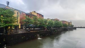 een rivier met een groep gebouwen naast een stad bij The Waterfront Shaw Lavasa in Lavasa