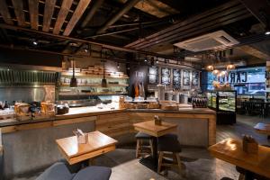 a restaurant with a counter with tables and chairs at The Picasso Boutique Serviced Residences Managed by HII in Manila