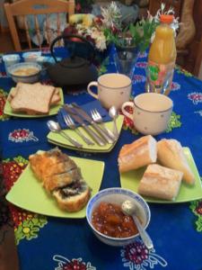 a table topped with plates of bread and soup and cups at Vosges Chambres d'hotes in Jeanménil