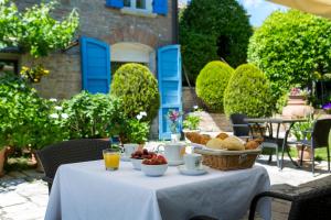 uma mesa com uma tigela de pão e uma cesta de frutas em Il Villino Hotel & SPA em Santarcangelo di Romagna