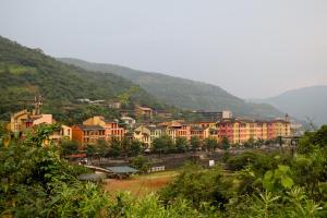 a group of buildings in front of a mountain at The Waterfront Shaw Lavasa in Lavasa