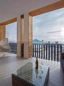 um quarto com uma mesa e copos de vinho numa varanda em Relais Castel Nuovo em Nápoles