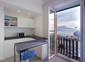 a kitchen with a balcony with a view of the ocean at Relais Castel Nuovo in Naples